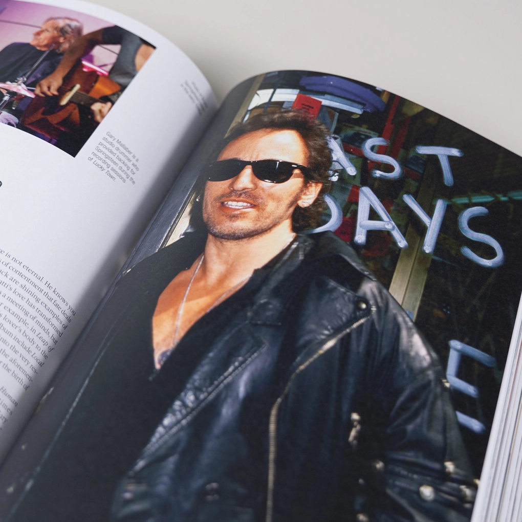 An interior photo of Bruce Springsteen in a black jacket and sunglasses